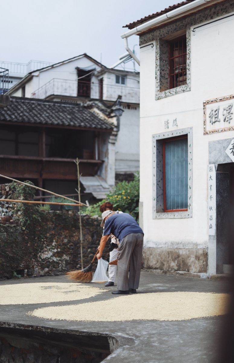 person bending beside house